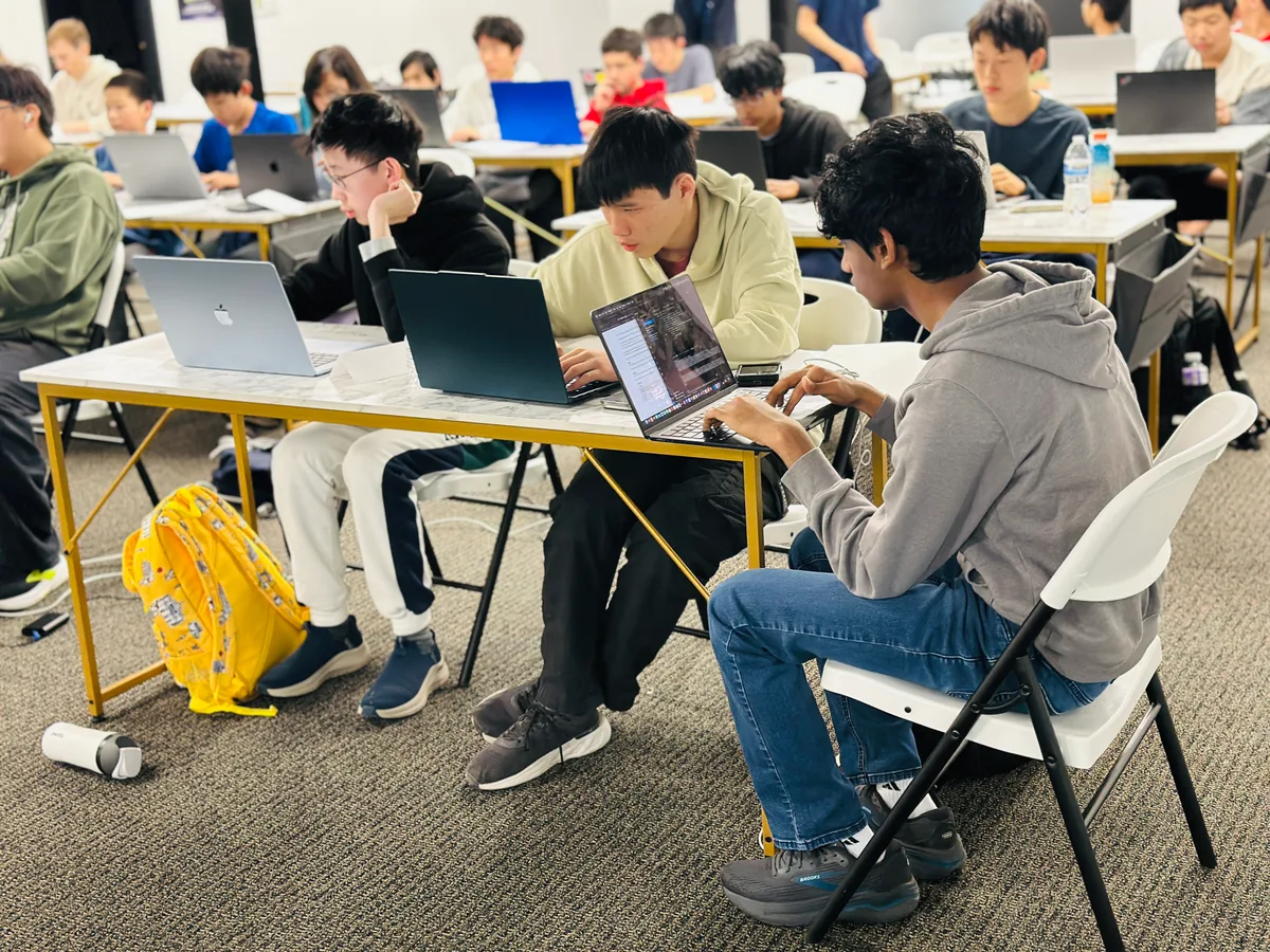 Competitors comparing ideas around their laptops